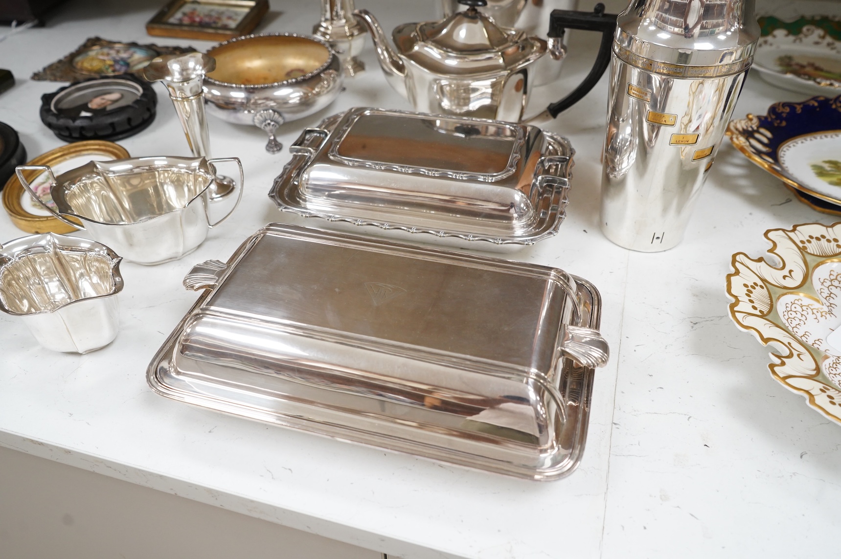 A collection of plated wares to include a vintage cocktail shaker with recipes, wine cooler and two plated entrée dishes including Art deco, largest 29cm wide